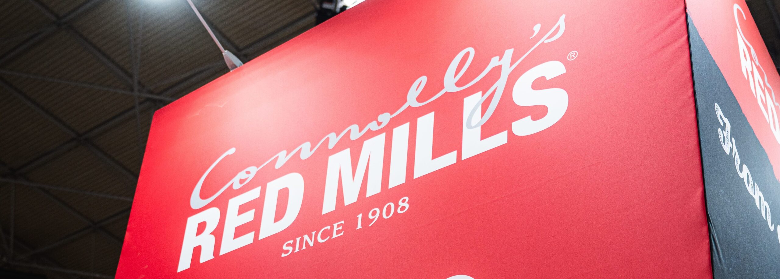 Red Connolly's RED MILLS sign hanging in an exhibition hall
